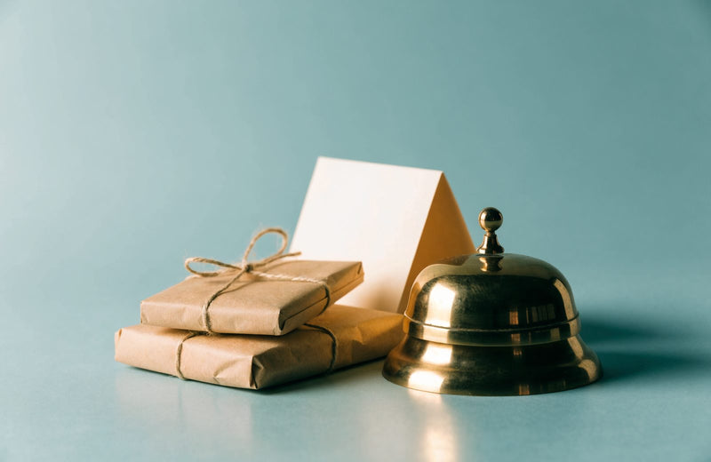 Brass service bell next to wrapped parcels